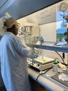 Female college student in a white lab coat works in a scientific lab.