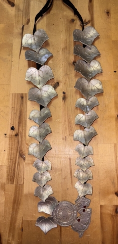 Silver medallion featuring ivy leaves.